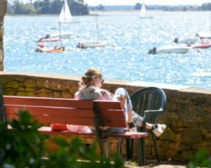 femme sur un banc devant la mer